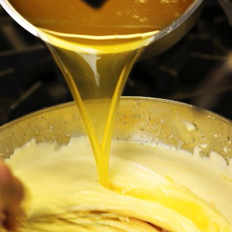 Sauce Hollandaise being prepared: adding clarified butter
